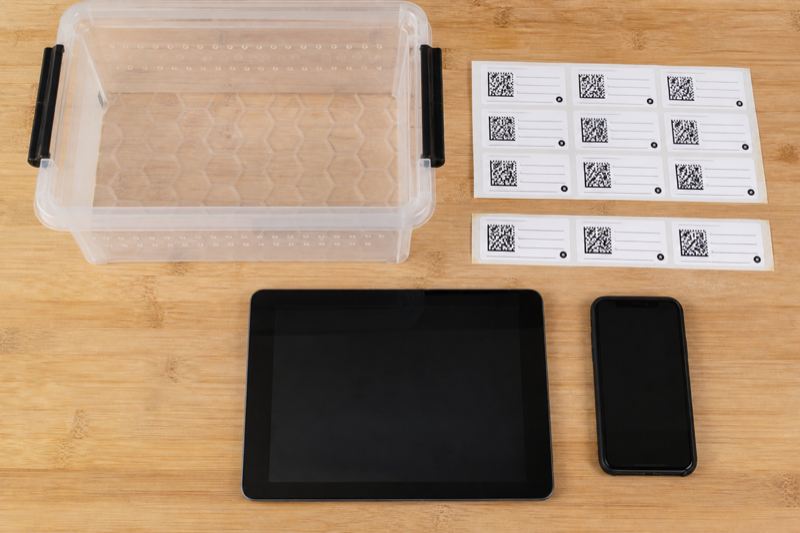 Reptile enclosure labels beside phone and tablet
